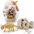 Robo Alive Dino Fossil Find egg packaging with dinosaur skull graphic, gold hammer, dinosaur skeleton figure and broken rock pieces on white background