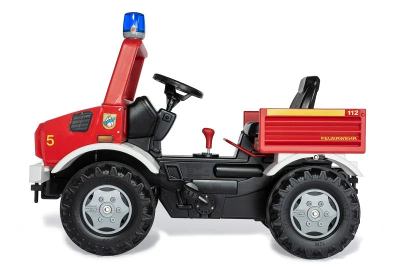 Side view of a red Rolly Fire Unimog pedal vehicle with blue light, black seat and large treaded tyres
