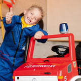 Child giving a thumbs up beside a red fire themed ride on vehicle fitted with the Rolly flashing blue light