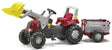 Rolly Junior red pedal tractor with front loader and farm trailer shown from the front on a white background