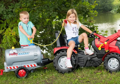 Two children using a Rolly tanker fitted with the blue pump and spraying water safely beside a lake