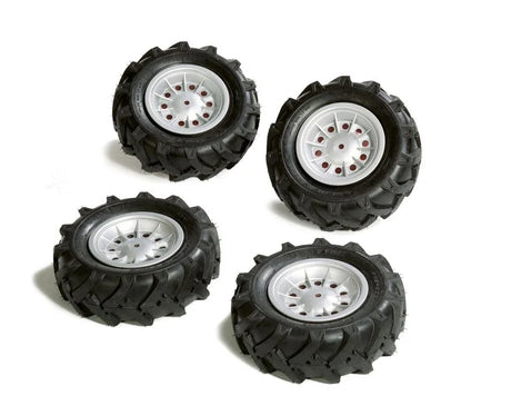 Four Rolly Trac air tyres with deep black tread and silver rims arranged on a white background
