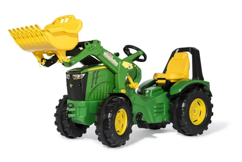 Green and yellow Rolly X Trac John Deere toy tractor with front loader raised on a white background
