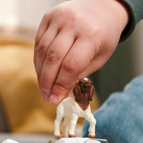 Schleich Boer Goat Kid figure being held upright by a hand
