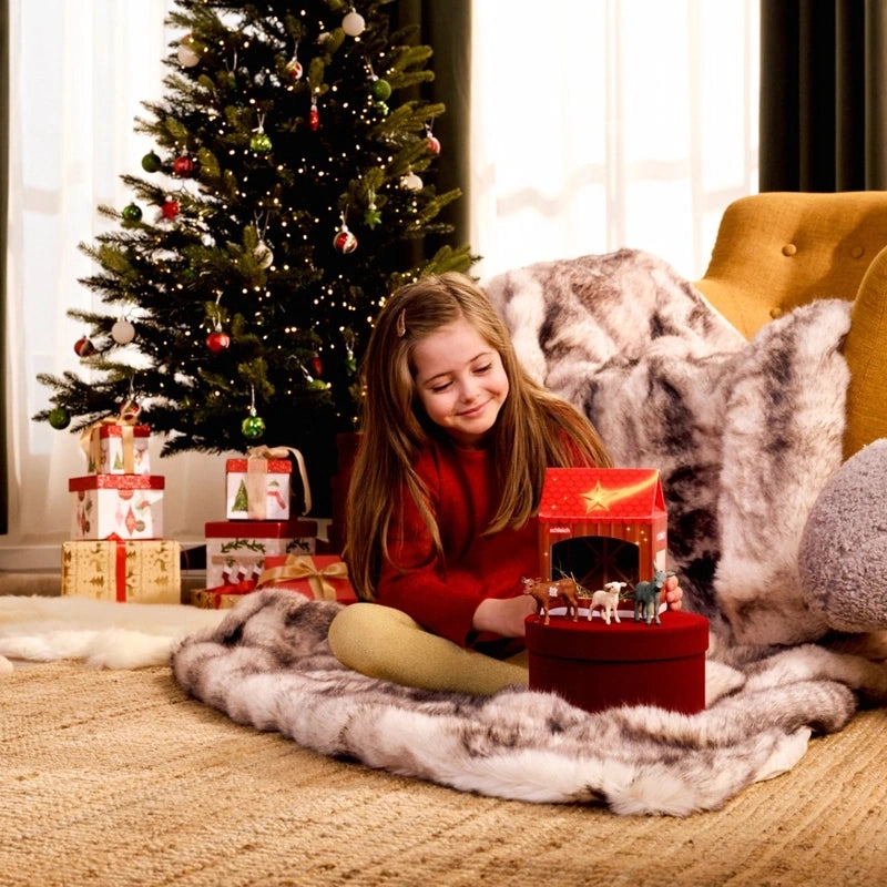 Child playing with Schleich Christmas Nativity Scene 42822 beside a Christmas tree