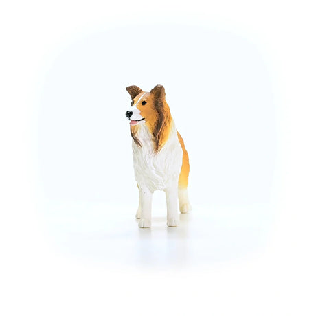 Schleich Collie figure facing forward with a white chest, brown face markings, black nose and pink tongue
