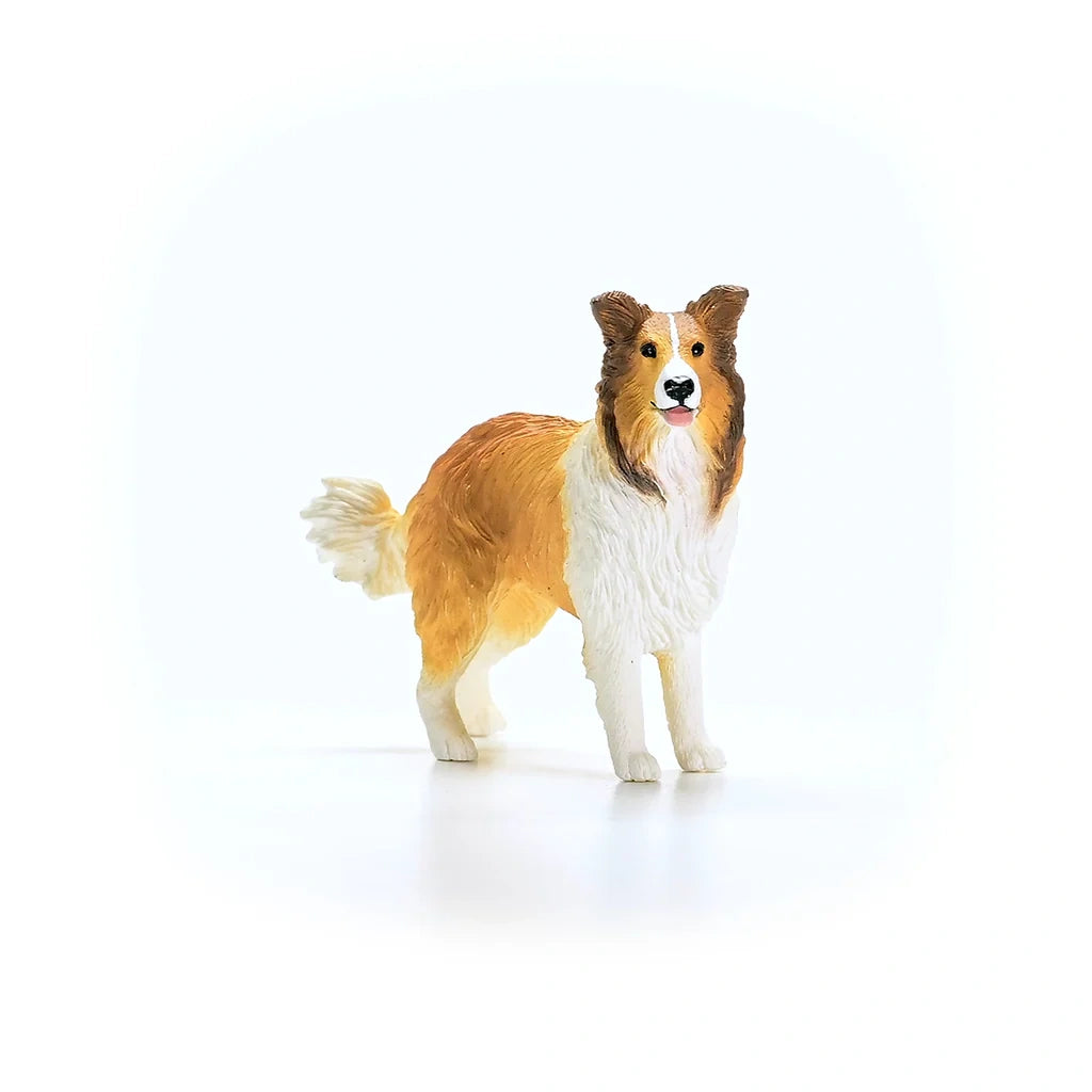 Schleich Collie figure facing slightly right with four white lower legs, brown facial markings and a raised tail 