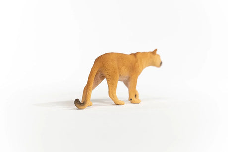 Schleich Cougar figure with a textured tan back, dark ear tips and a long tail curled at the dark tip.