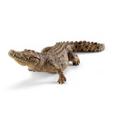 Schleich Crocodile figure with its mouth closed, textured scales and a curved spotted tail.