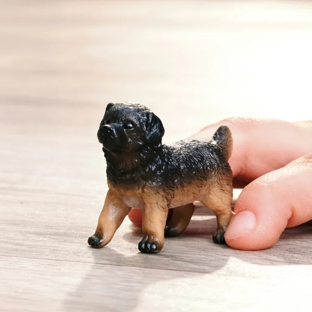 Schleich German Shepherd Puppy figure in a play scene with a child’s hand