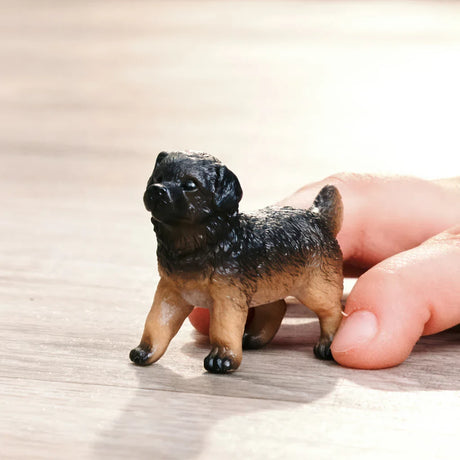 Schleich German Shepherd Puppy figure in a play scene with a child’s hand
