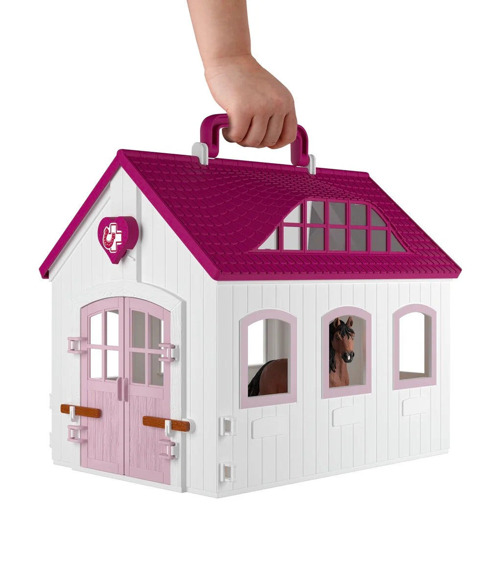Schleich Happy Horse Hospital 42787 folded into its closed clinic shape and being carried by the roof handle
