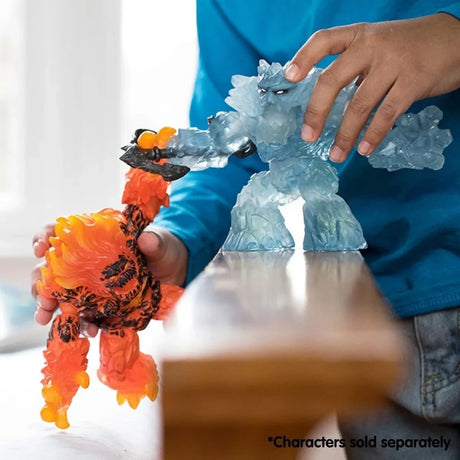 Child holding the Schleich Ice Giant and Lava Smasher figures beside a wooden table, with the Ice Giant anchor touching the Lava Smasher