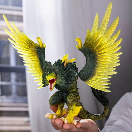 Schleich Jungle Raptor figure held in one hand with its wings raised and mouth open