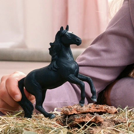 Schleich Lusitano Stallion figure rearing on straw beside a hand