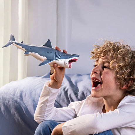 Child holding the Schleich Megalodon figure and pretending it is roaring