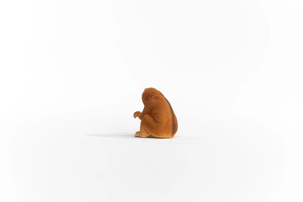 Schleich Slow Loris figure shown from the rear left with brown textured fur and one arm raised.