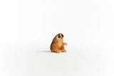 Schleich Slow Loris figure seated with brown textured fur, a pale face and curled fingers on one raised hand.