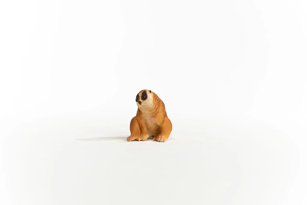 Schleich Slow Loris figure seated with its head turned left, dark eye markings and both feet visible.