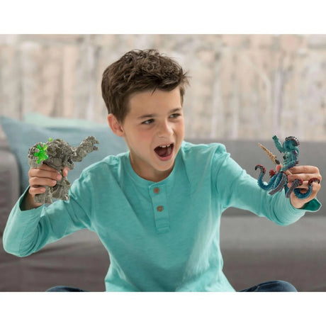Boy holding a Schleich Stone Monster figure and a blue creature figure