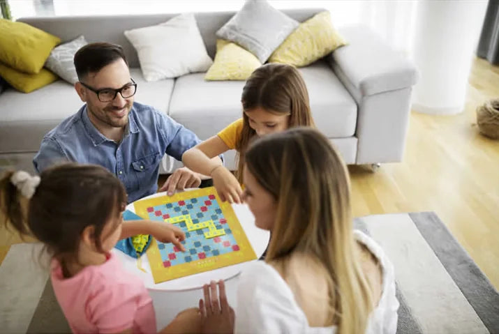 Family playing Scrabble Junior board game together in living room Ireland