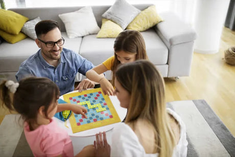 Family playing Scrabble Junior board game together in living room Ireland