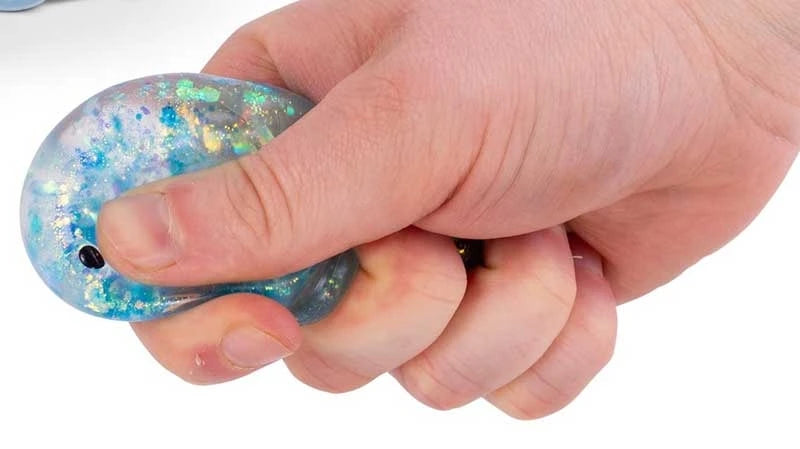 Blue Scrunchems Sugar Bear being squeezed by hand with glitter pieces visible inside the translucent squishy body