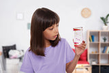 Girl wearing a purple T-shirt looking at a Sensory Motion Bubbler Stair with pink droplets inside