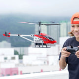 Silverlit Flybotic Sky Knight helicopter flying outdoors with child holding the remote controller