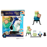 Harry Potter Slime Life Polyjuice Potion slime kit packaging displayed beside green potion bottles, a black cauldron shaped accessory, a small flask and a mixing spoon.
