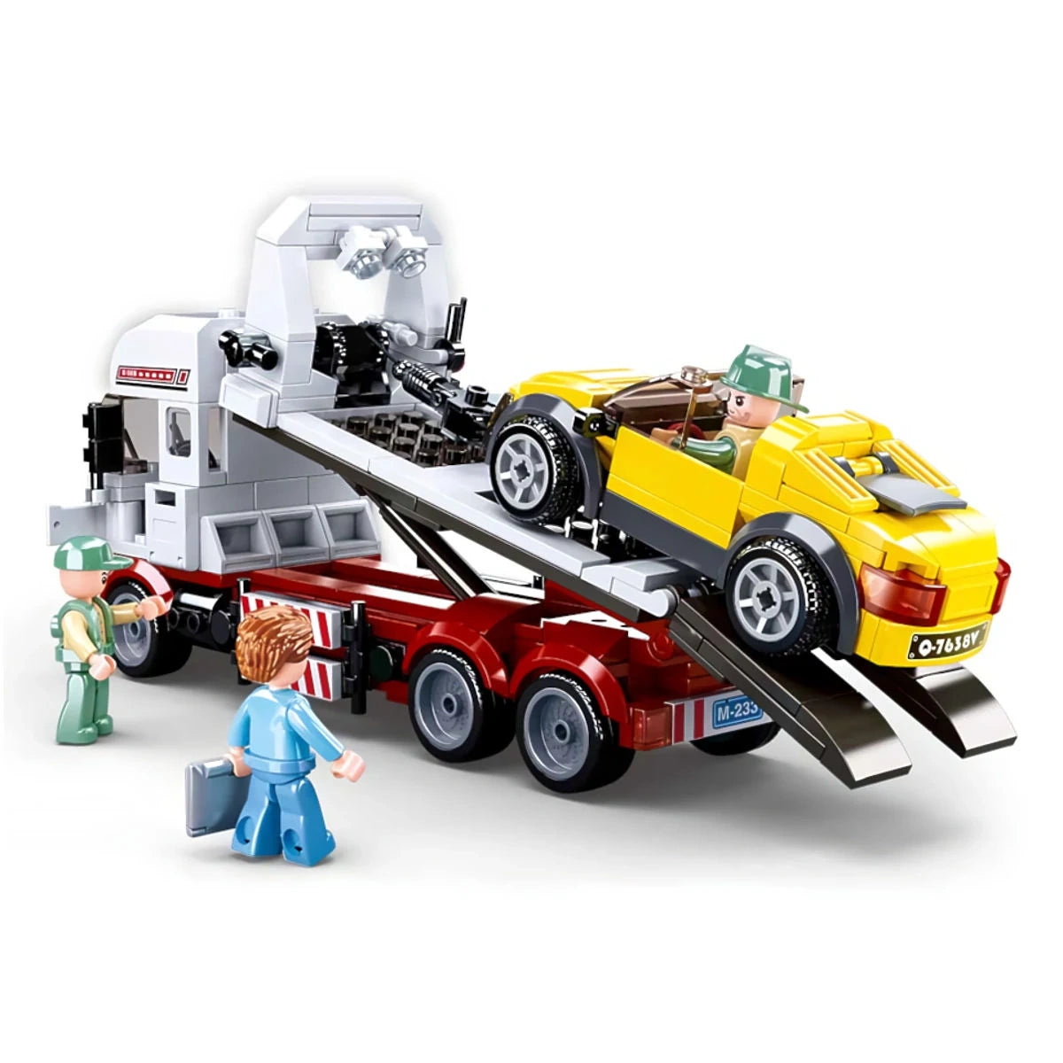 Sluban Town Car Trailer showing the yellow sports car positioned on the raised flatbed tow truck with rear loading ramps extended and three figures around the vehicle