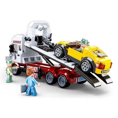 Sluban Town Car Trailer showing the yellow sports car positioned on the raised flatbed tow truck with rear loading ramps extended and three figures around the vehicle