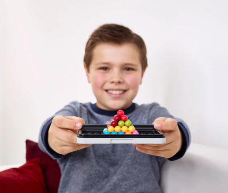 Child holding SmartGames IQ Puzzler Pro with completed pyramid – Ireland