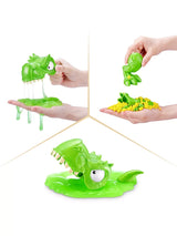 Hands squeezing green dinosaur head over slime and lifting dinosaur body pieces from yellow sand pile