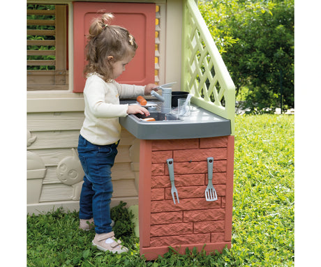 Child using the sink area of the Smoby Life Nature Playhouse kitchen