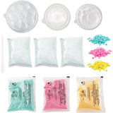 So Bomb DIY Flower Bath Bomb Kit ingredients and accessories arranged on a white background, including packets of bath bomb powders, coloured decorations and flower moulds.