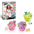 So Slime Experience Deluxe Set Pop Style retail box displayed alongside three finished pink, green and purple slime pots decorated with sweets, a frog charm, paw prints, flowers and a coconut drink.