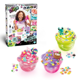 So Slime Experience Deluxe Set Pop Style retail box displayed alongside three finished pink, green and purple slime pots decorated with sweets, a frog charm, paw prints, flowers and a coconut drink.