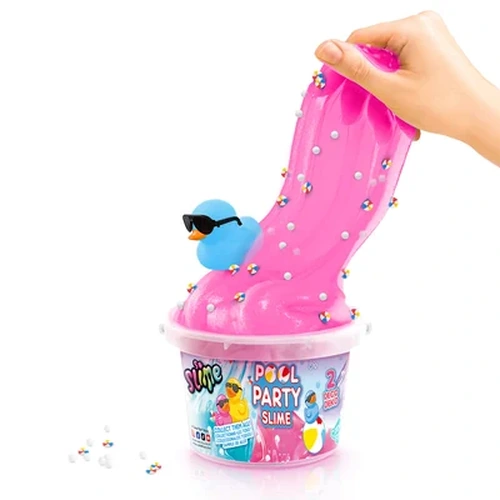 Hand pulling bright pink So Slime Pool Party slime from a clear bucket, with a blue duck wearing black sunglasses sitting in the slime among colourful decorations and white foam beads.