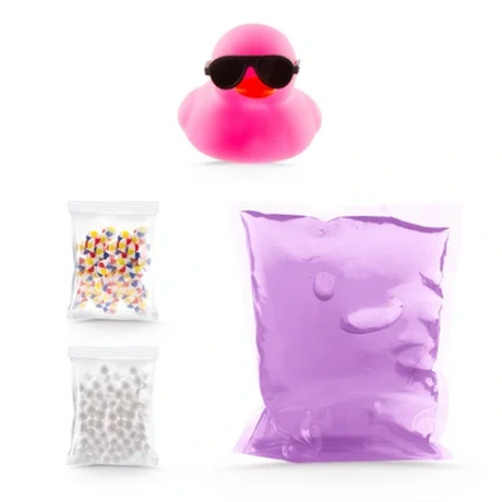 So Slime Ducky Pool Party contents showing a pink rubber duck wearing black sunglasses, a sealed pouch of purple slime and two small packets of colourful decorations and white foam beads.