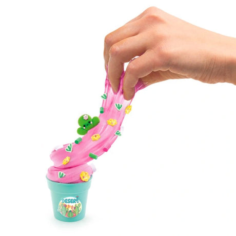 Pink slime being stretched from a turquoise Desert pot with flower, leaf and cactus decorations