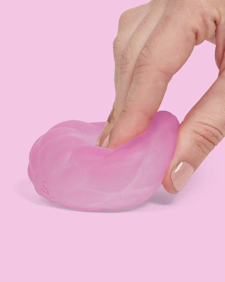 Speks Gump Surface Quilt Moon Jelly squishy being pressed by hand, showing the soft pink quilted surface