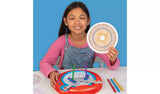 Child holding a spiral pattern beside the Spirograph Electronic Machine