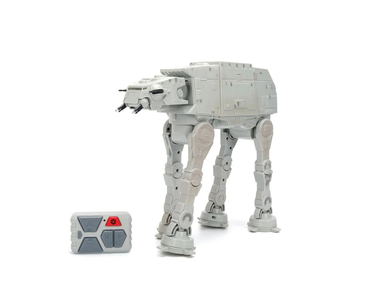 Star Wars RC Walking AT-AT in grey with four mechanical legs, swivelling head and twin front cannons, shown beside its grey remote controller.