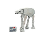 Star Wars RC Walking AT-AT in grey with four mechanical legs, swivelling head and twin front cannons, shown beside its grey remote controller.