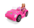 Steffi Love doll wearing a purple floral dress seated in a bright pink convertible with grey wheels, transparent windscreen and colourful stickers on the bonnet.