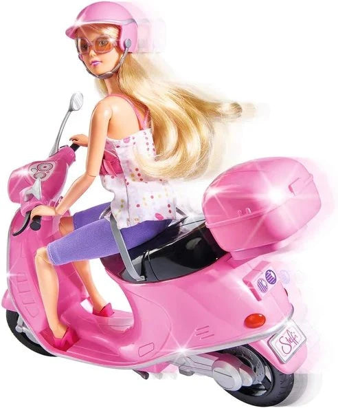 Steffi Love doll riding the pink scooter from the side, wearing a pink helmet and sunglasses with long blonde hair behind her