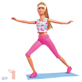 Steffi doll posed in a wide stance on her blue yoga mat, bottle beside her – Ireland