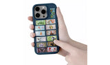 Hand holding a phone with Minecraft stickers arranged across the back of the case