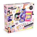 Style 4 Ever 4 in 1 Scrapbooking Studio Pro retail box viewed from the front and left side, showing the purple and pink craft workstation, decorative tapes, 3D stickers, paper cutting and embossing examples, and decorated journal.